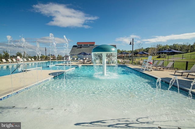 community pool featuring fence and a patio