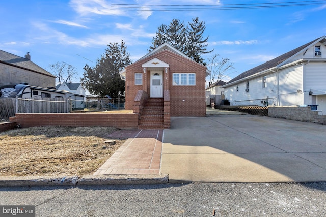 view of front of property featuring fence and brick siding