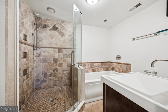 bathroom with a stall shower, visible vents, a bath, and vanity