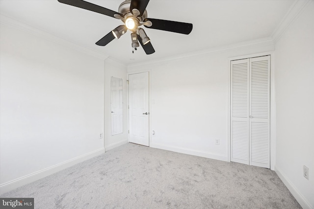 unfurnished bedroom featuring baseboards, a ceiling fan, ornamental molding, carpet, and a closet