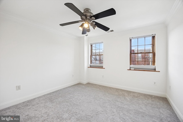 empty room featuring a healthy amount of sunlight, carpet floors, visible vents, and ornamental molding