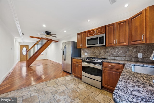 kitchen with stone tile floors, tasteful backsplash, stainless steel appliances, and a sink