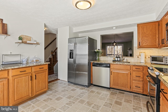 kitchen featuring pendant lighting, a toaster, brown cabinets, open shelves, and appliances with stainless steel finishes