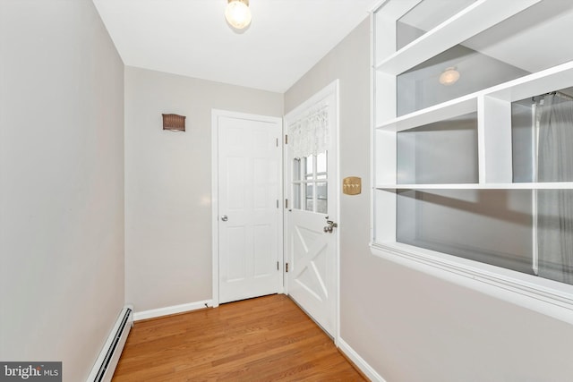 doorway with a baseboard radiator, baseboards, and wood finished floors