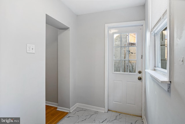 doorway with marble finish floor and baseboards