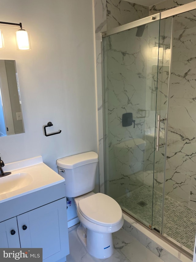 bathroom with toilet, marble finish floor, a marble finish shower, and vanity