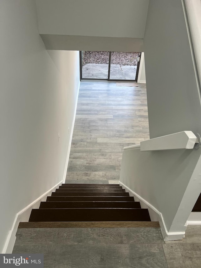 staircase featuring baseboards and wood finished floors