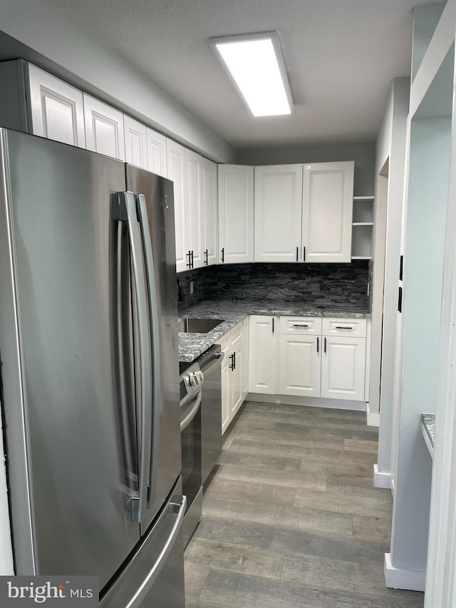 kitchen featuring tasteful backsplash, stainless steel appliances, light wood-style floors, white cabinetry, and open shelves