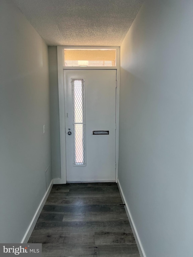 entrance foyer featuring a textured ceiling, dark wood-type flooring, and baseboards