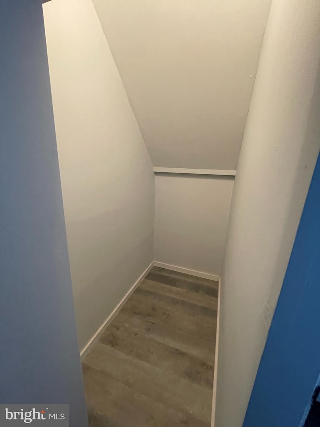 staircase featuring vaulted ceiling and wood finished floors