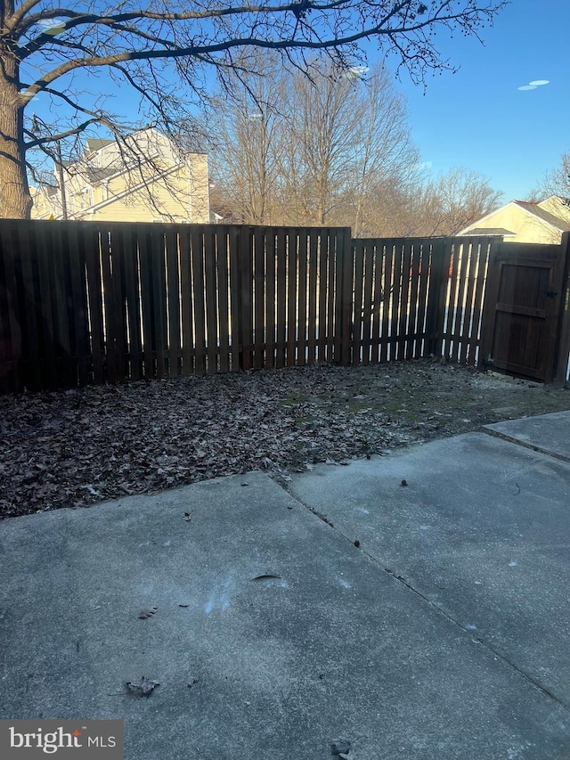 view of gate with a patio and fence