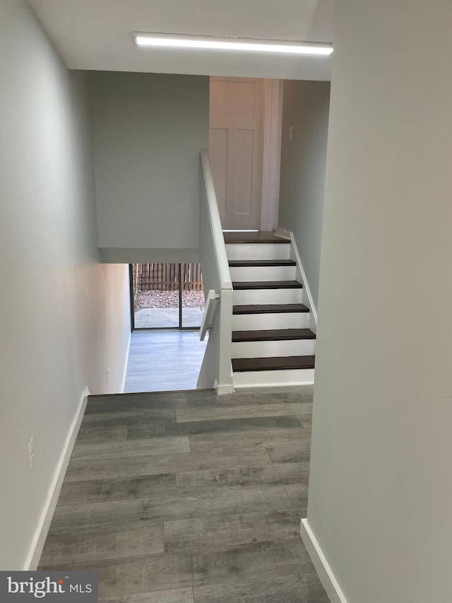 stairway featuring wood finished floors and baseboards