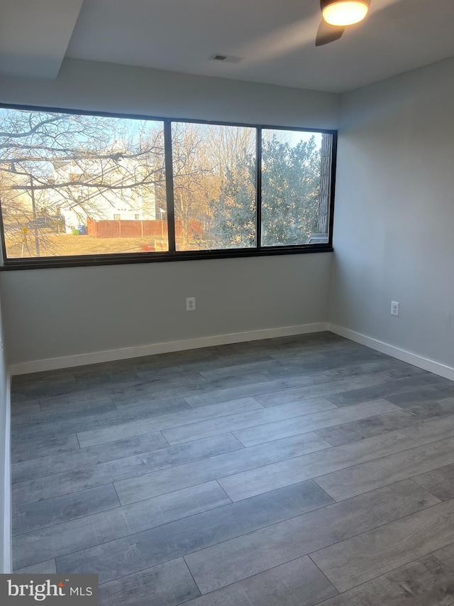 empty room featuring visible vents, baseboards, and wood finished floors