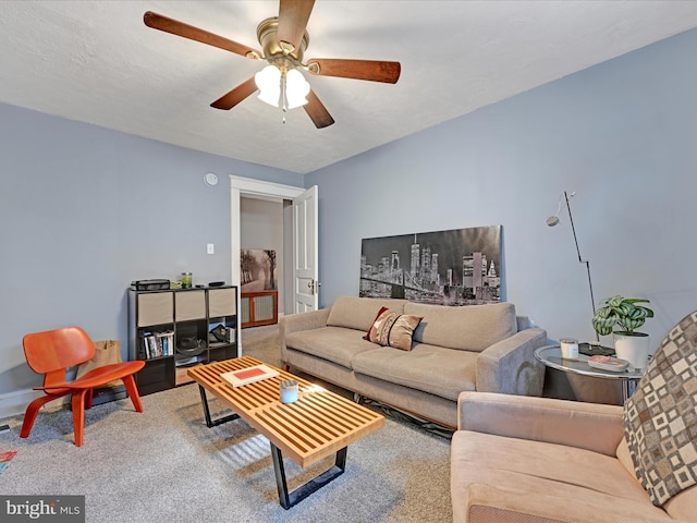 carpeted living area with a ceiling fan and a textured ceiling