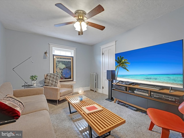 living room featuring a textured ceiling, a ceiling fan, baseboards, radiator, and carpet