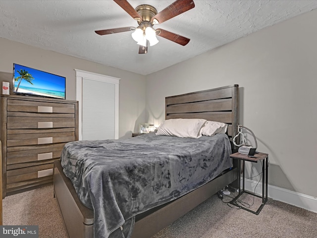 carpeted bedroom with a textured ceiling, a ceiling fan, and baseboards