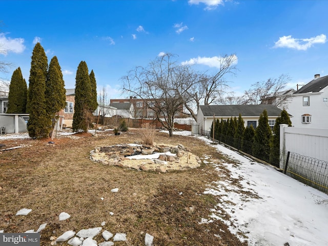 yard layered in snow featuring a residential view and fence