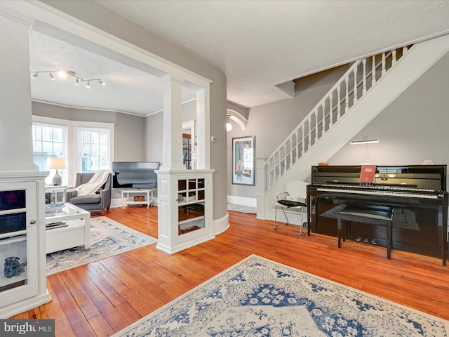 entrance foyer with ornate columns, baseboards, stairway, and wood finished floors