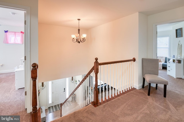 hall featuring a wealth of natural light, carpet flooring, and an upstairs landing