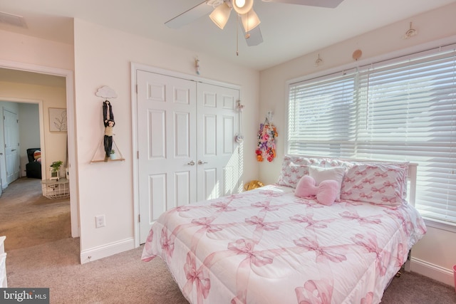 carpeted bedroom featuring a ceiling fan, a closet, visible vents, and baseboards