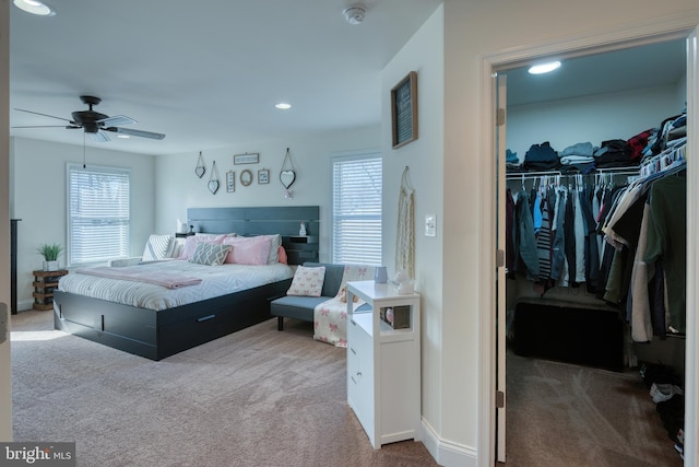 carpeted bedroom with multiple windows, a closet, a walk in closet, and recessed lighting