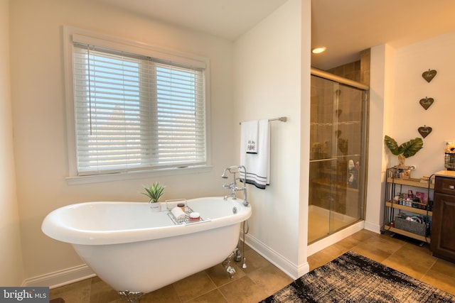 bathroom featuring a shower stall, baseboards, and a freestanding bath