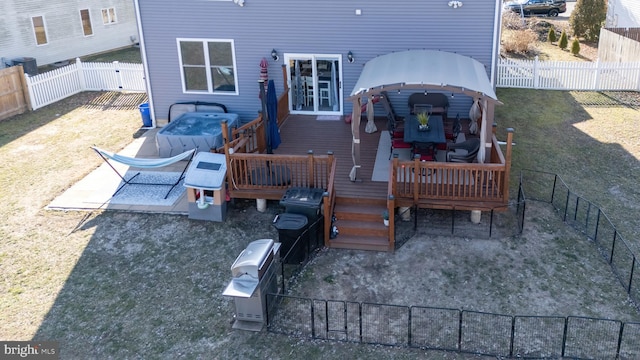 exterior space with a fenced backyard, a wooden deck, and a gazebo