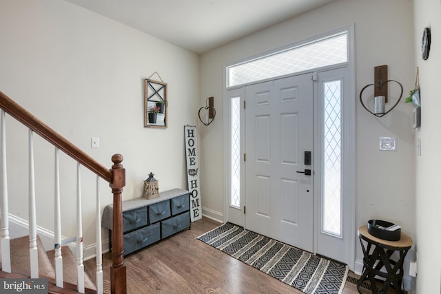 entryway featuring stairs, baseboards, and dark wood-style flooring