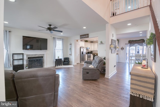 living area with plenty of natural light, wood finished floors, and a glass covered fireplace