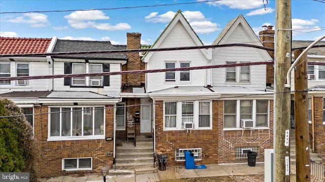 view of property with cooling unit and brick siding