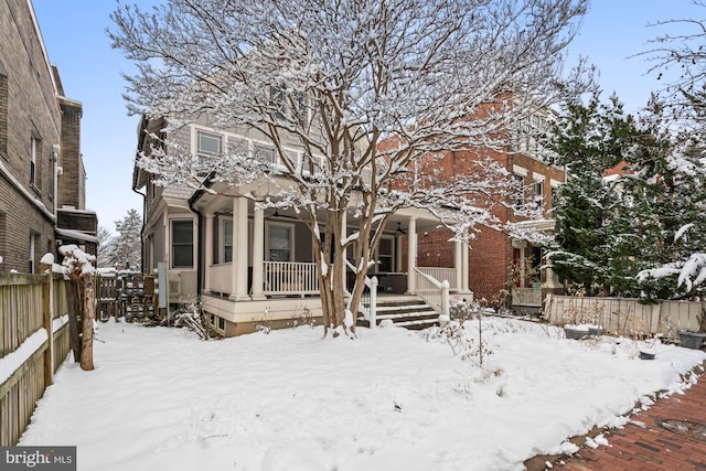 view of front of home featuring covered porch and fence