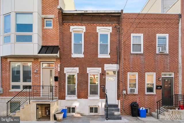 multi unit property featuring entry steps, a standing seam roof, brick siding, and metal roof