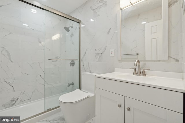 bathroom featuring a marble finish shower, toilet, marble finish floor, vanity, and tile walls