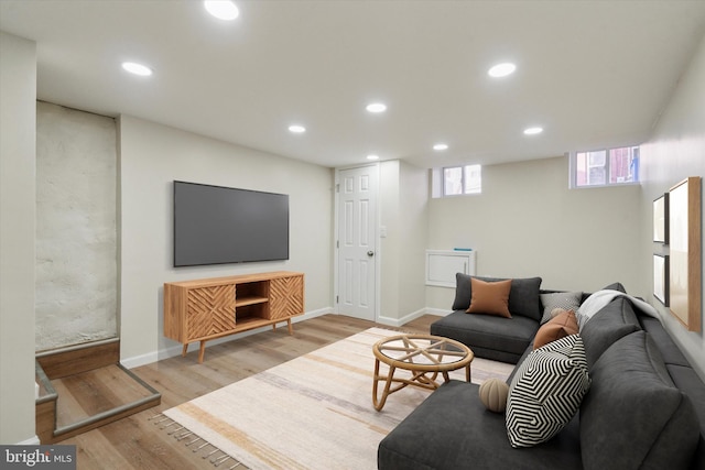 living area featuring baseboards, light wood-type flooring, and recessed lighting