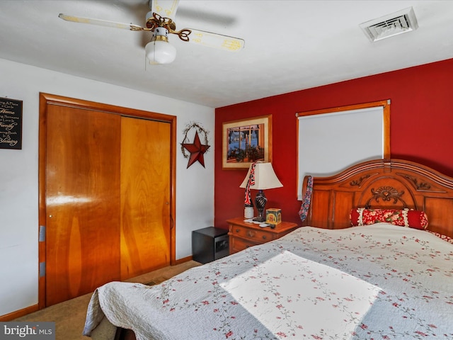 bedroom featuring carpet floors, visible vents, baseboards, a ceiling fan, and a closet