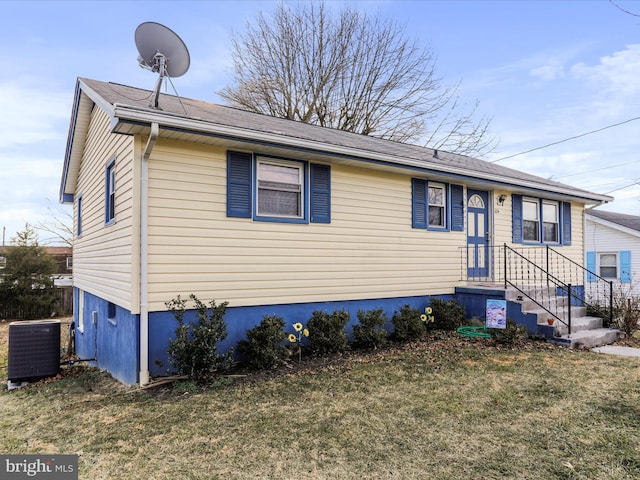 view of front of property with cooling unit and a front lawn