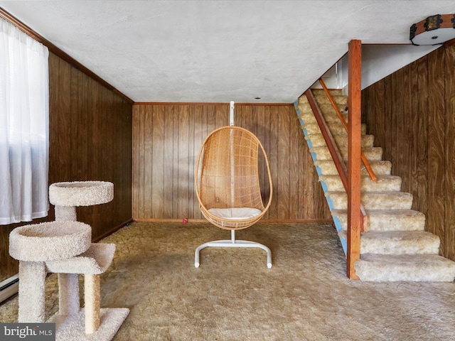 unfurnished room featuring carpet floors, wooden walls, and stairs