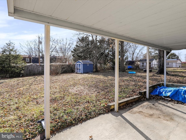 view of yard featuring an outbuilding, a shed, a patio area, and a fenced backyard