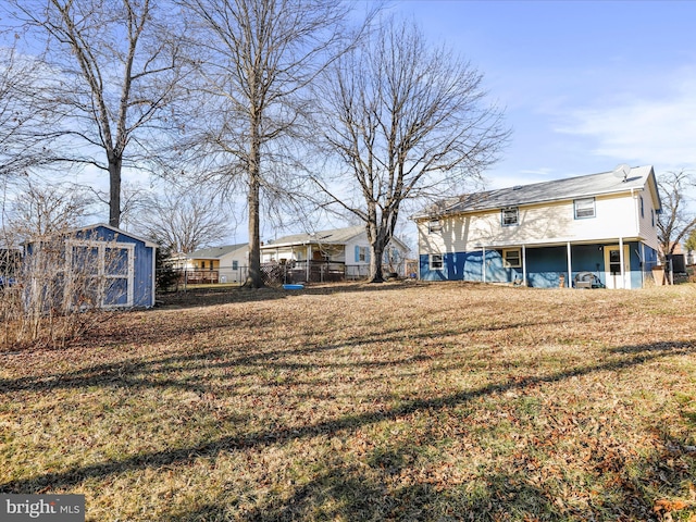 view of yard featuring an outbuilding, fence, and a storage unit