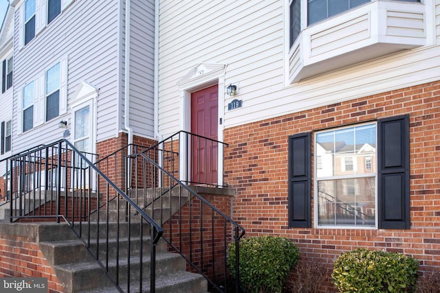 view of exterior entry featuring brick siding