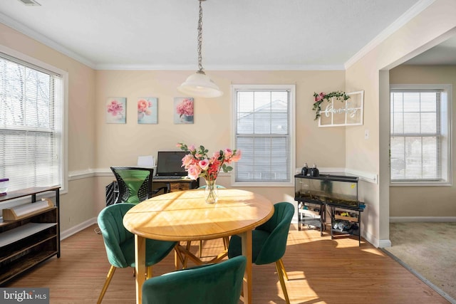 dining room featuring ornamental molding, wood finished floors, a wealth of natural light, and baseboards