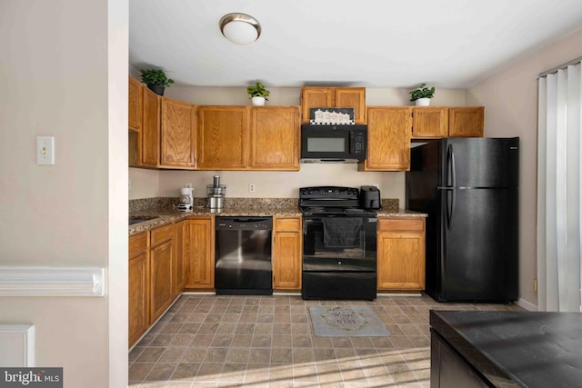 kitchen with black appliances, brown cabinetry, and light stone countertops