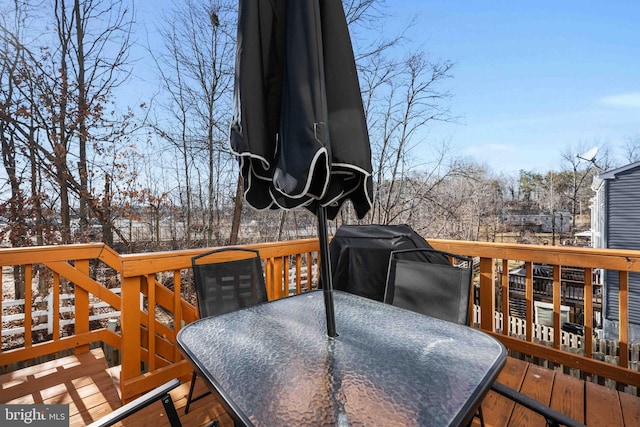 wooden deck featuring grilling area and outdoor dining space