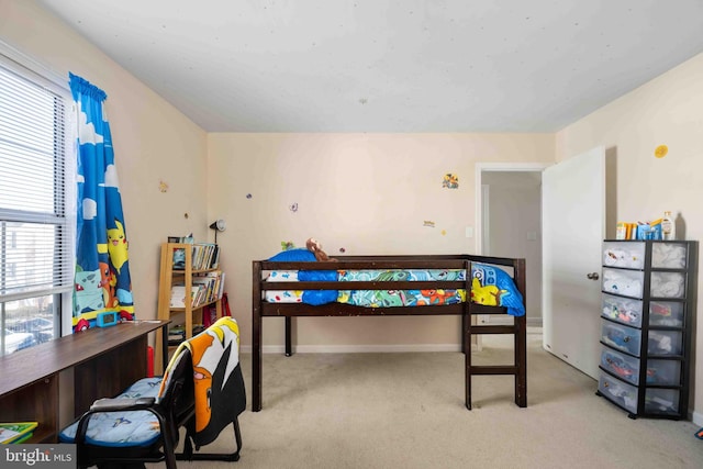 carpeted bedroom featuring multiple windows and baseboards