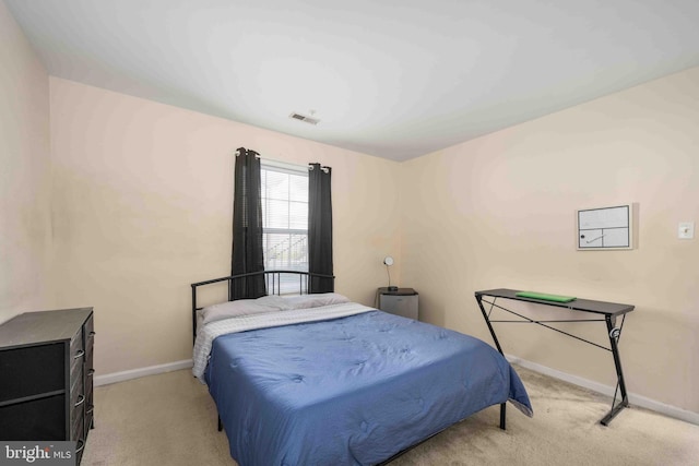 bedroom with baseboards, visible vents, and light colored carpet