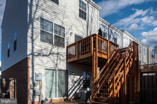 back of property featuring stairs, fence, a deck, and central AC