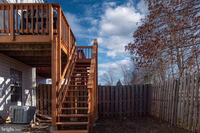 view of yard featuring central air condition unit, a fenced backyard, stairs, and a deck