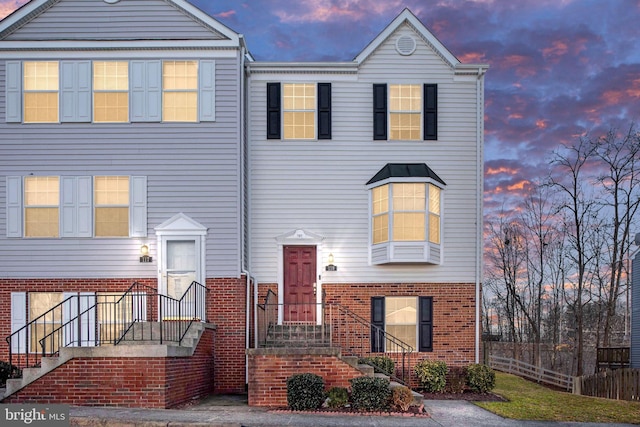 view of front of home with fence and brick siding