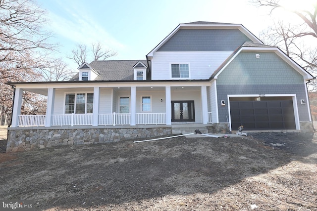 view of front of home featuring a porch, french doors, dirt driveway, and a garage