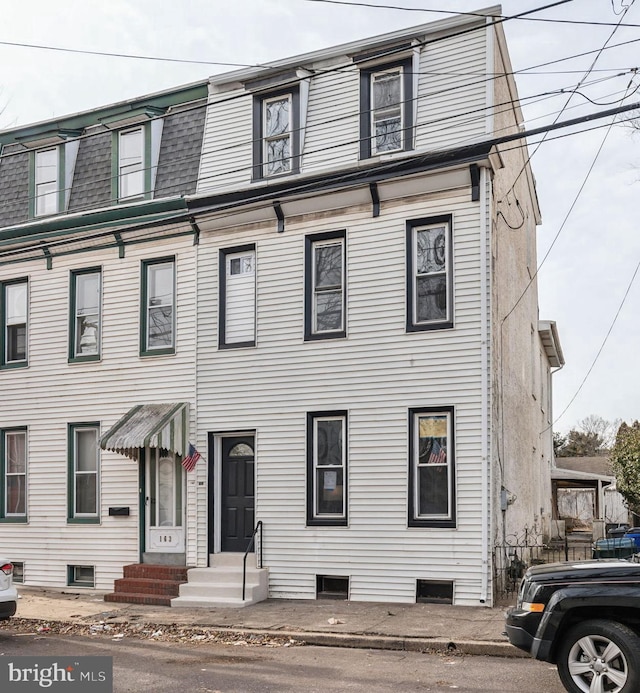 multi unit property featuring entry steps, mansard roof, and roof with shingles